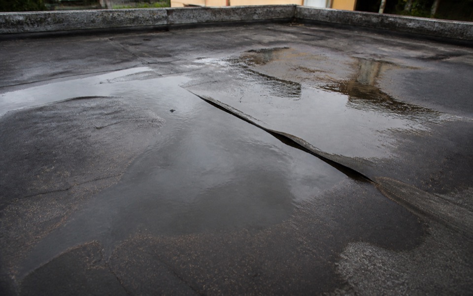 Agua retenida sobre una cubierta plana deteriorada